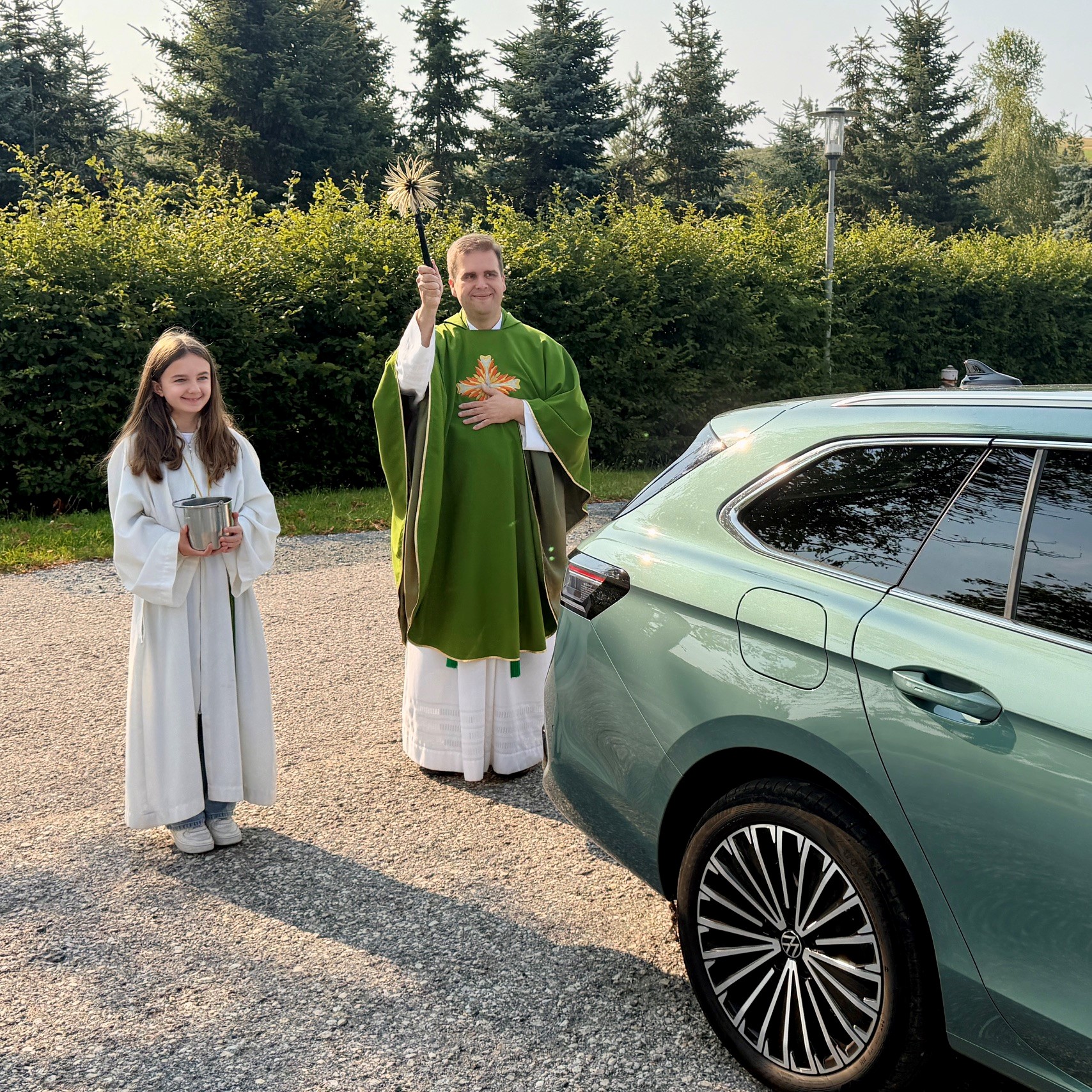 Pfarrer Detlef Pötzl besprengt anlässlich der Fahrzeugsegnung ein Auto mit Weihwasser.