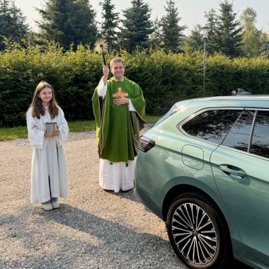 Pfarrer Detlef Pötzl besprengt anlässlich der Fahrzeugsegnung ein Auto mit Weihwasser.