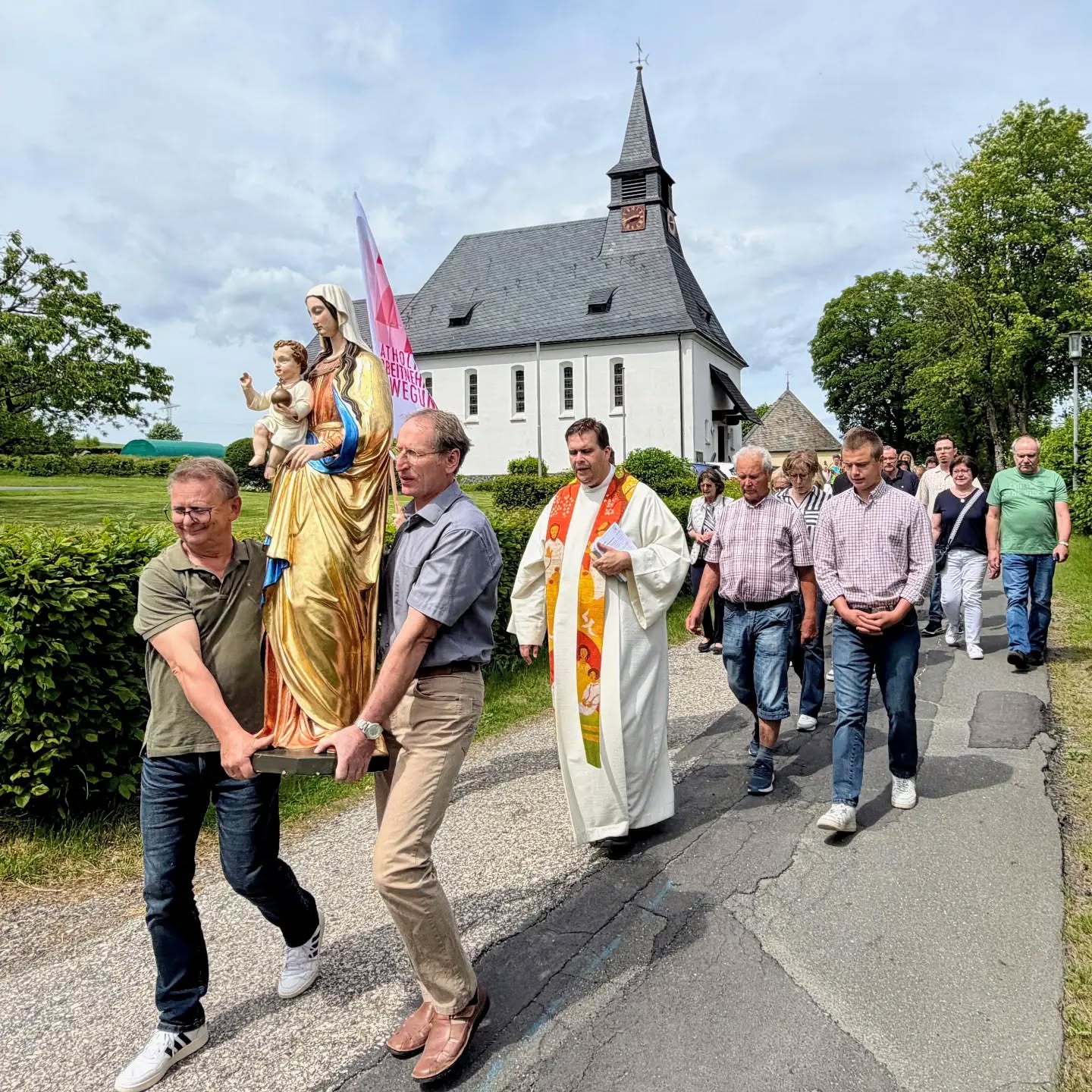 Prozession mit der Marienfigur von der Kirche in den Pfarrsaal.