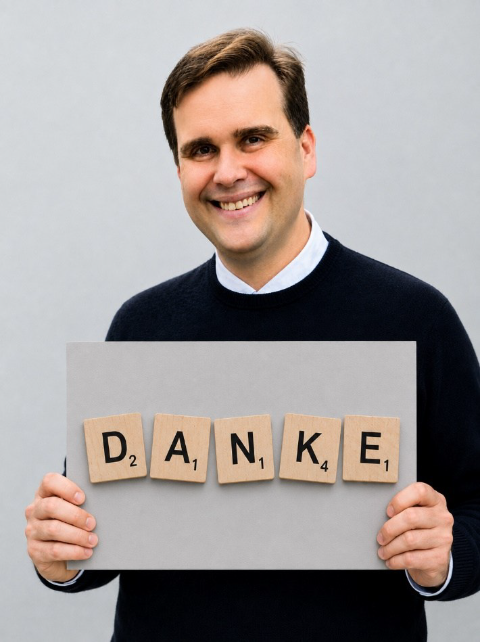 Pfarrer Detlef Pötzl hält ein Schild mit der Aufschrift Danke in den Händen.